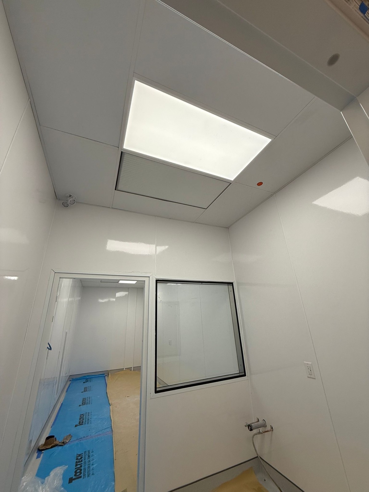 Freshly installed glossy white FRP wall and ceiling panels in a clean room