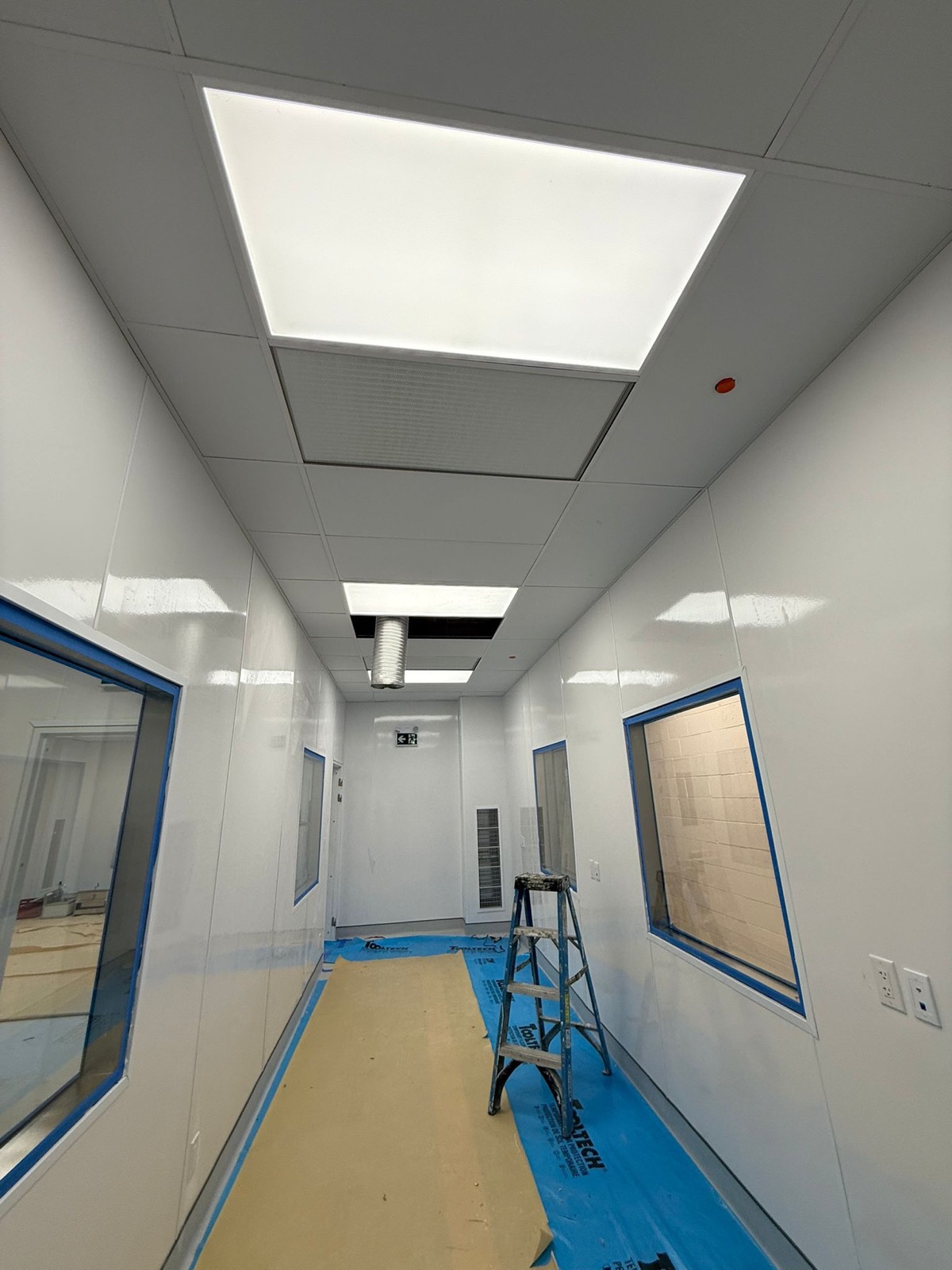 Wide cleanroom corridor finished with white FRP wall and ceiling panels